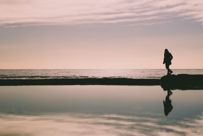 轮廓的女人在海滨的岩层
